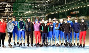Zdjęcie przedstawia zawodników łyżwiarstwa szybkiego wraz z trenerami na arenie lodowej w Tomaszowie Mazowieckim