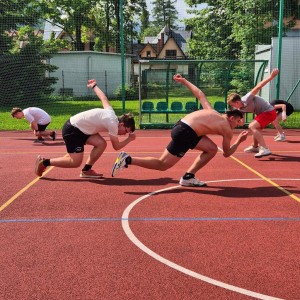 Zdjęcie przedstawia łyżwiarzy szybkich podczas treningu na boisku szkolnym przy SMS Zakopane