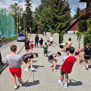 Zdjęcie przedstawia łyżwiarzy szybkich podczas treningu na boisku szkolnym przy SMS Zakopane