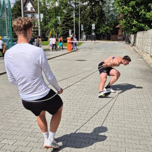 Zdjęcie przedstawia łyżwiarzy szybkich podczas treningu na boisku szkolnym przy SMS Zakopane